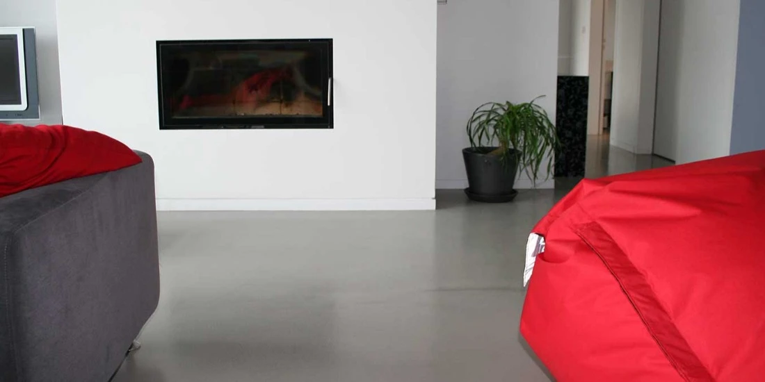 Intérieur contemporain lumineux avec poêle à bois encastré dans un pilier en pierre sculptée texturée gris anthracite