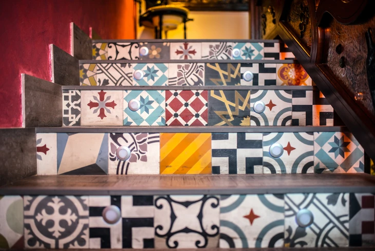 Escalier intérieur décoré avec carreaux de ciment colorés aux motifs géométriques et floraux variés