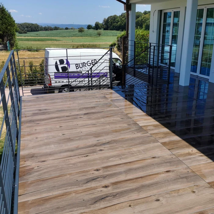 Terrasse extérieure avec carrelage grand format imitation bois, pose en décalé, finition mate