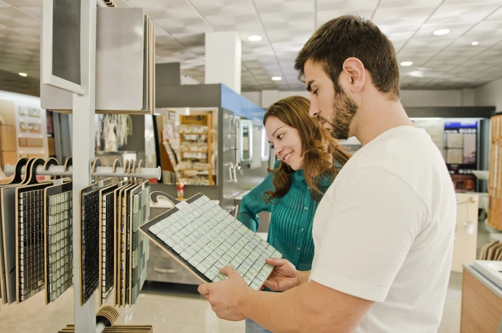 Couple consultant des échantillons de carrelage dans un magasin spécialisé