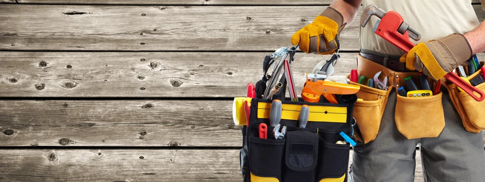 Ouvrier en extérieur portant une ceinture à outils professionnelle sur planches de bois