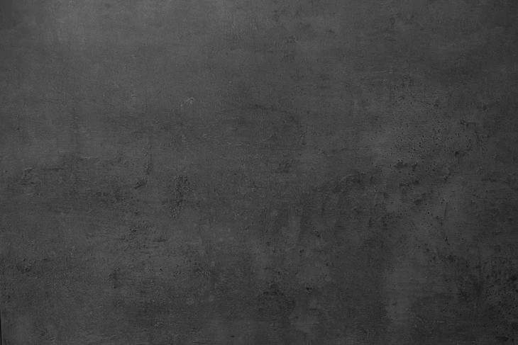 Surface en béton brut gris foncé avec texture rugueuse et granuleuse