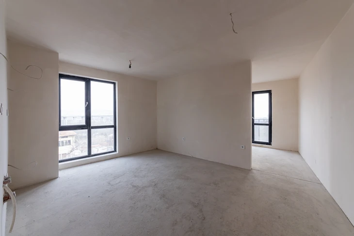 Appartement neuf en cours de finition avec murs en béton brut et enduit de lissage