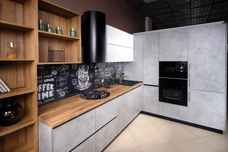 Cuisine moderne en L avec îlot central, combinant façades grises effet béton et éléments en bois naturel