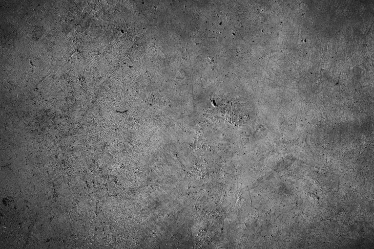 Surface de béton gris rugueuse avec traces d'usure et imperfections naturelles