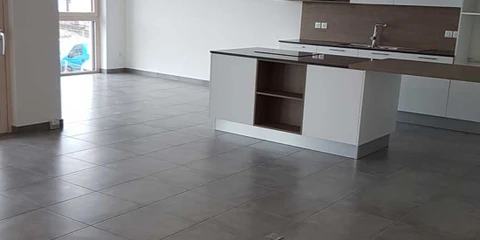 Salle de bain moderne avec vasque à poser en pierre naturelle granit gris, robinet mitigeur chromé col de cygne, sur tablette console murale en bois clair