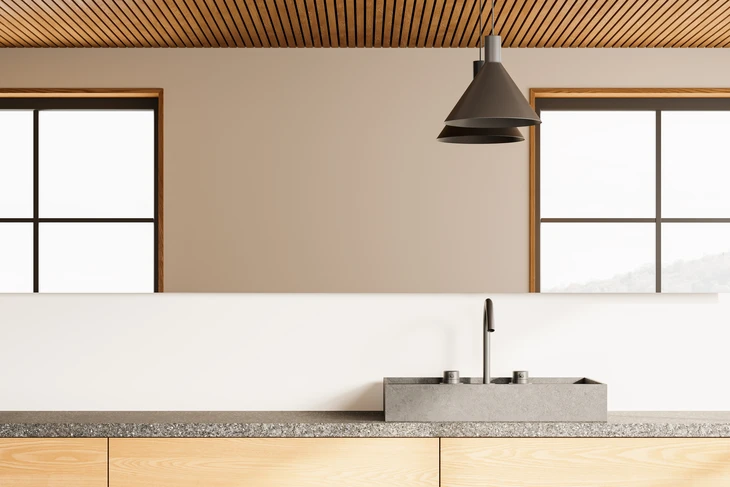 Cuisine moderne minimaliste avec îlot central, évier rectangulaire en béton ciré et robinetterie noire