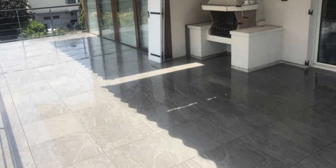 Salle de bain moderne avec vasque à poser en pierre naturelle granit gris, robinet mitigeur chromé col de cygne, sur tablette console murale en bois clair