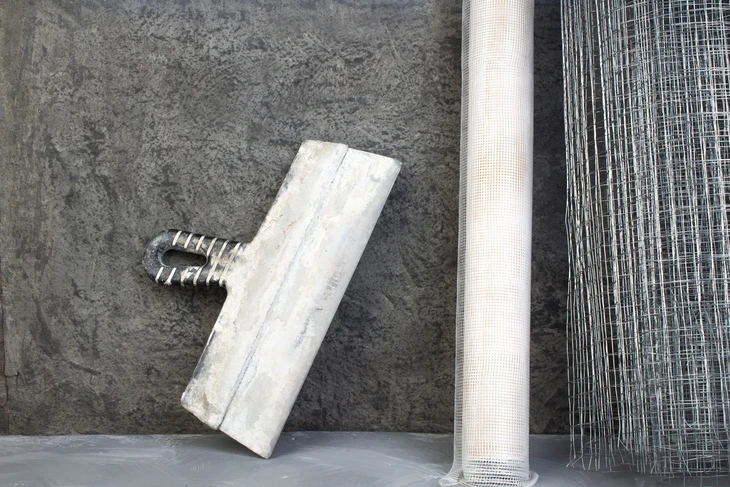 Chantier de construction extérieur avec outils de maçonnerie posés sur dalle béton