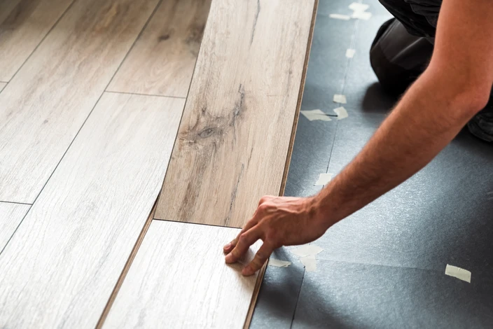 Intérieur résidentiel moderne avec salon ouvert, mur en briques apparentes rouges, sol en carrelage gris grand format