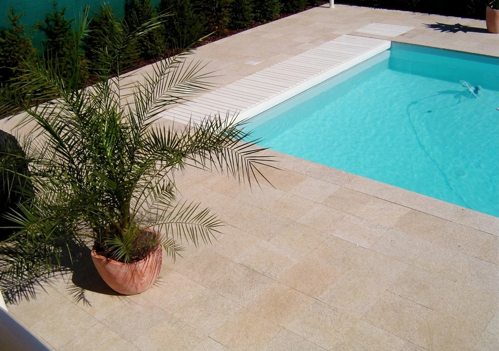 Piscine intérieure privée avec liner bleu foncé, carrelage en grès cérame gris, paroi en pierre de parement claire