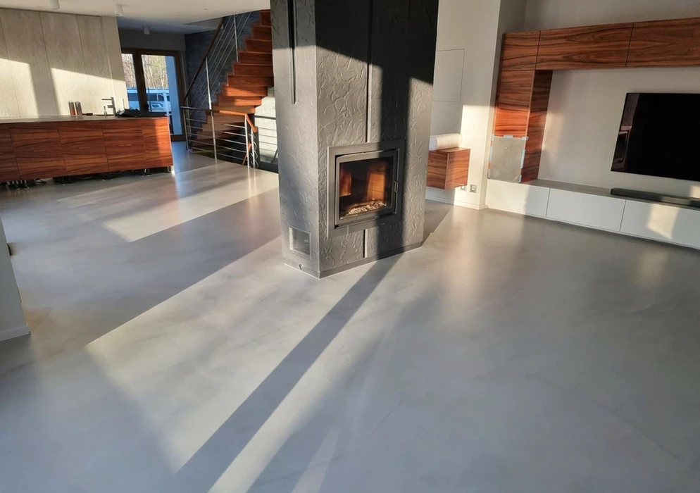 Entrée de maison avec sol en carreaux de ciment à motifs floraux bleus, verts et bordeaux sur fond blanc cassé